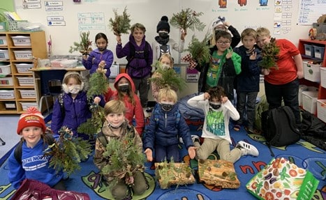 A group photo of a grade school class with their wreaths.